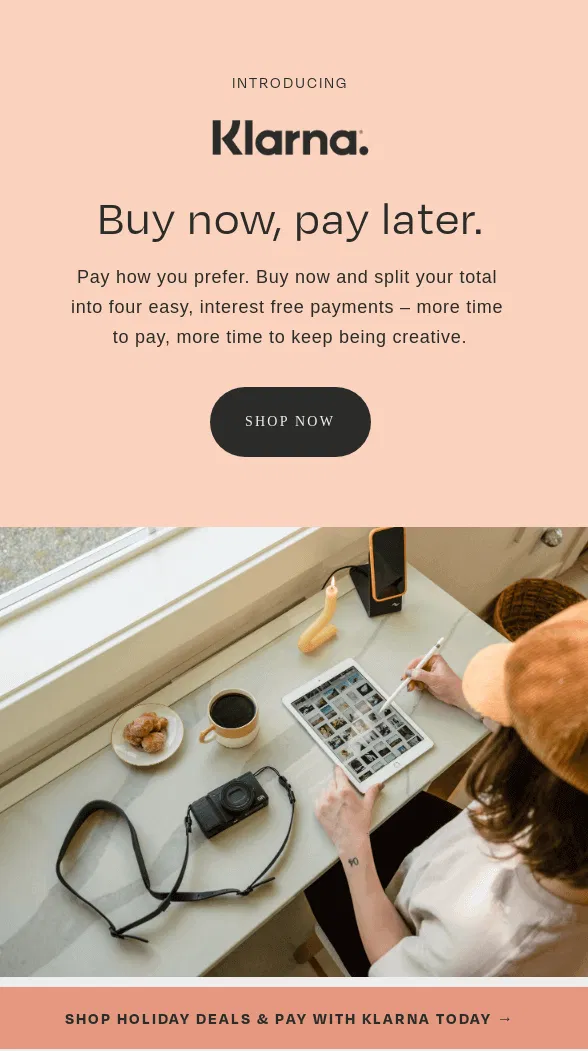 Klarna example of Minimalist Email Design A person at a desk with a tablet, camera, and coffee. Text promotes Klarna's "Buy now, pay later" service.